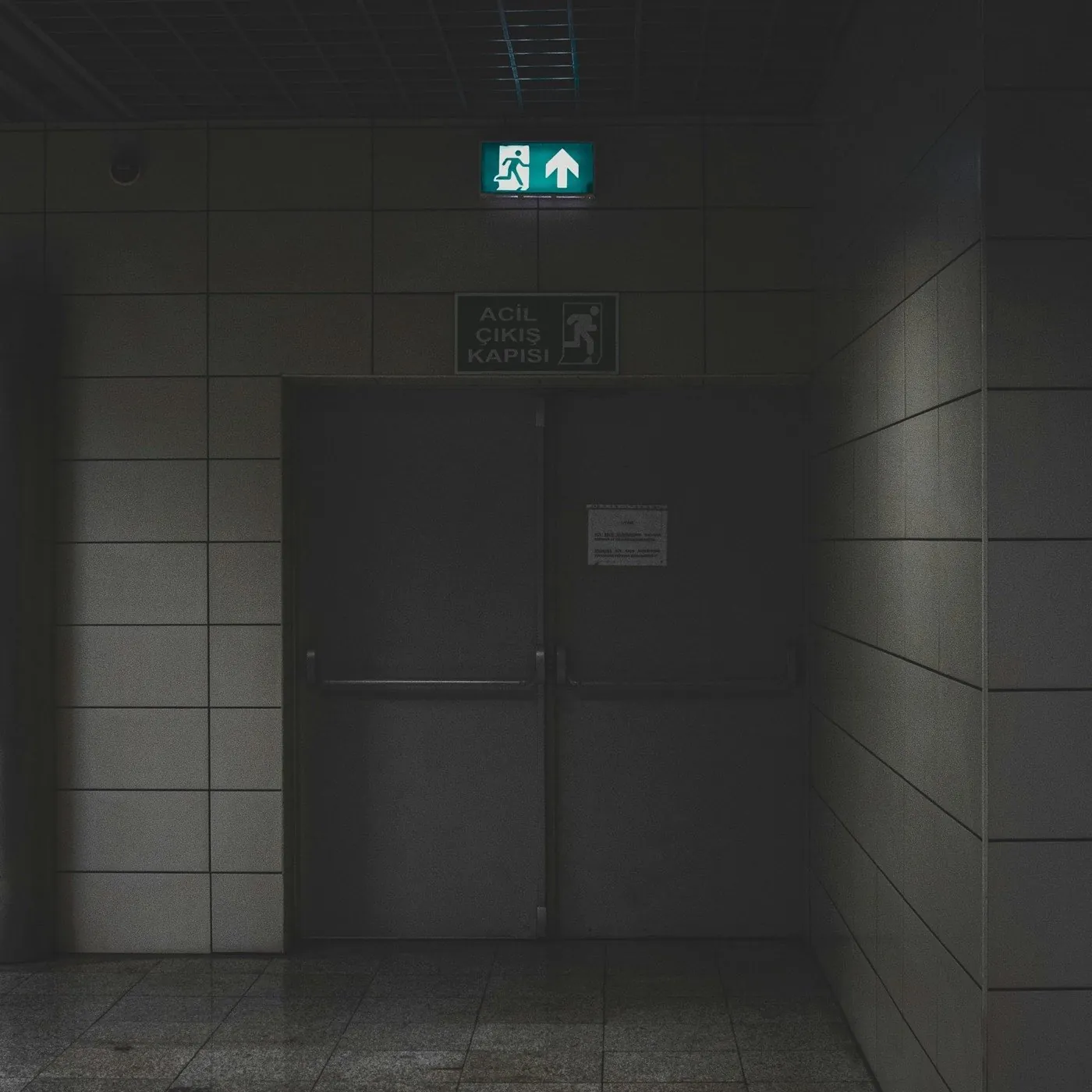 Couloir sombre avec un panneau de sortie de secours