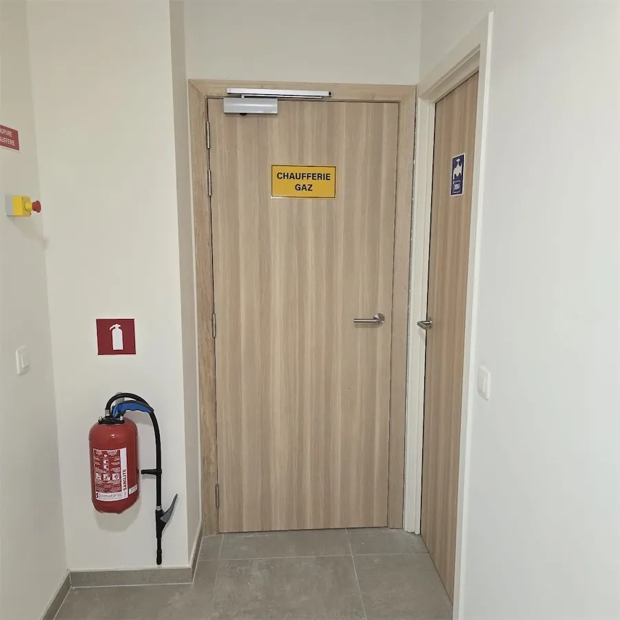 Porte de chaufferie gaz, avec un extincteur à côté