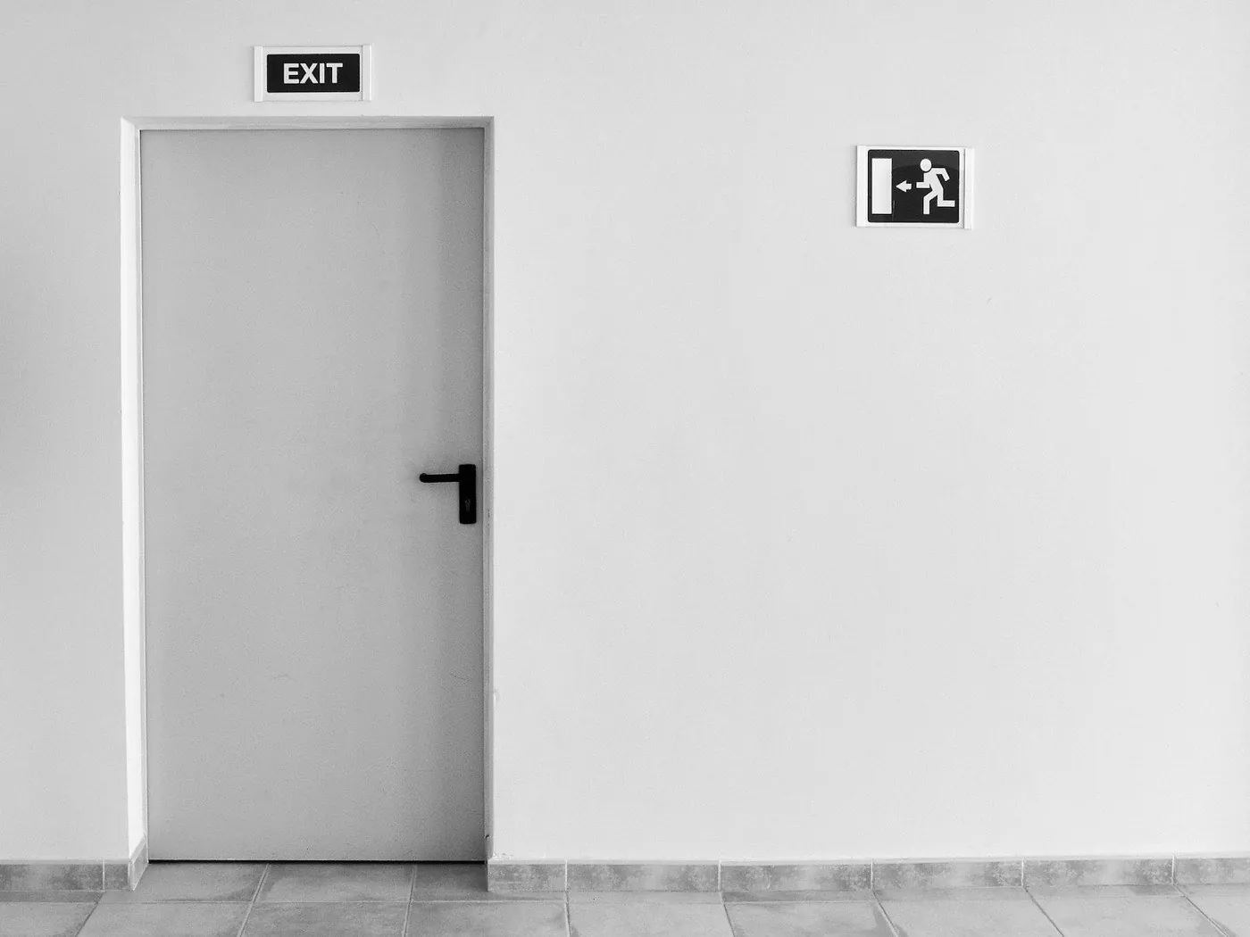 Porte grise sous un panneau de sortie de secours